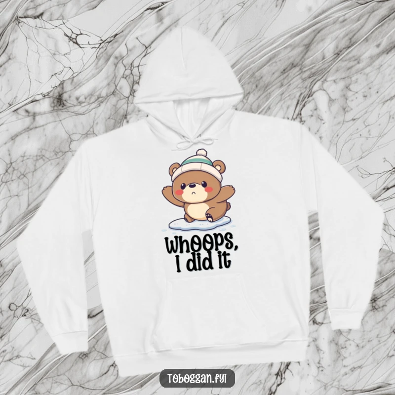 Funny Hoodie: A startled bear wearing a tiny toque comically slips on ice, offering cozy humor and winter vibes.