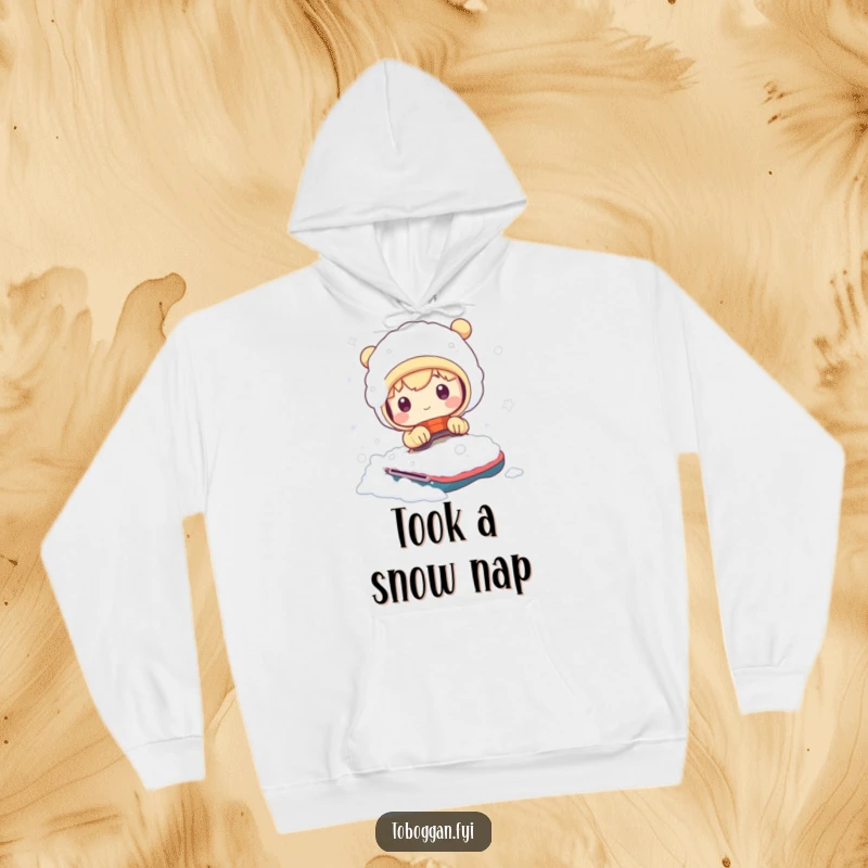 Funny hoodie showing a cute character comically emerging from a snowy heap after a bumpy winter ride, ideal for cozy humor.